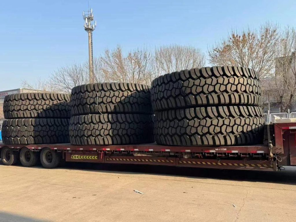 Large stack of heavy-duty tires on a flatbed trailer ready for transport.